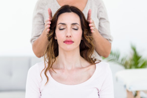 Calm woman receiving Spiritual Healing treatment on white background